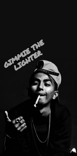 戴著帽子的年輕男子拿著一支香煙，頭頂上方有文字「Gimmie the lighter」。 — 說唱歌手 壁紙