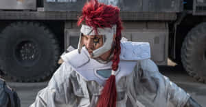 穿著白色未來盔甲的cosplayer，紅髮，臉上畫有星星圖案，靠近一輛軍用卡車。 — 戰士 壁紙