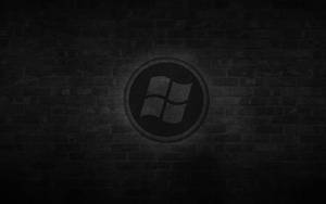 帶有聚光燈效果的深色磚牆上的Windows標誌。