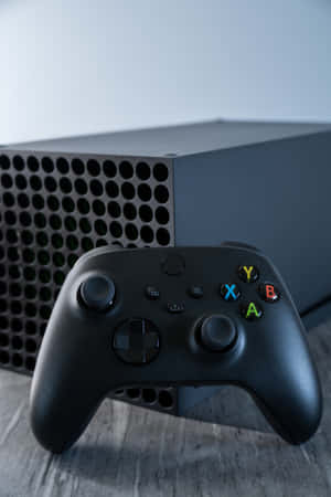 黑色Xbox手掣和主機在木質表面上 — 小米Pad 8 壁紙