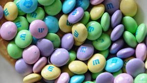一個裝滿色彩繽紛粉彩M&M's糖果的碗。 — 朱古力 壁紙