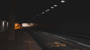 夜晚空無一人的城市隧道，帶有巴士站標記和頭頂燈光。 — 最黑暗地牢 壁紙