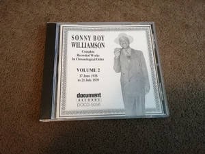 棕色地毯上用於Sonny Boy Williamson音樂的CD盒。 — 黑白 壁紙
