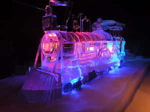 在雪夜中閃耀粉紅和藍光的冰製火車雕塑。 — 冰 GIF 壁紙