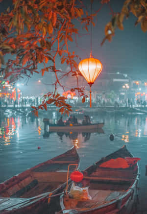 溫暖的燈籠照亮霧氣瀰漫的夜湖上的木船，伴隨著倒影和遠處的燈光。 — Oppo Pad 5 壁紙