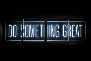 一個明亮的霓虹燈牌，上面寫著「Do Something Great」，背景為黑暗。 — 音樂 GIF 壁紙