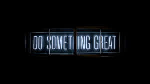 一個明亮的霓虹燈牌，在黑暗的房間裡顯示「Do Something Great」的訊息。 — 鼓舞人心的 壁紙