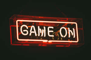 一個紅色霓虹燈牌，上面寫著 game on，懸掛在黑暗中。 — MacBook Air M2 壁紙