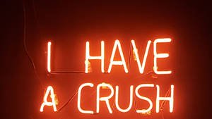 一個紅色霓虹燈牌在黑暗房間中顯示「I HAVE A CRUSH」。 — 語錄 壁紙