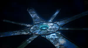 一個發光的藍色圓形工藝品，帶有放射狀臂，在黑暗環境中。 — 最後一戰：無限 壁紙