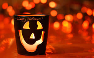 一個發光的傑克南瓜燈燭台，帶有「Happy Halloween!」文字。 — 16:10 壁紙