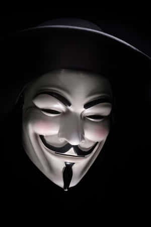 一個白色嘅 Guy Fawkes 面具，帶住一個大笑容同黑色帽，喺黑色背景前。 — 鬼滅之刃面具 壁紙