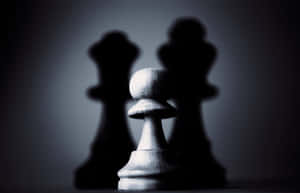 一個白色國際象棋兵，背後有模糊的黑色國王陰影，在黑暗背景上。 — MacBook Air M4 壁紙