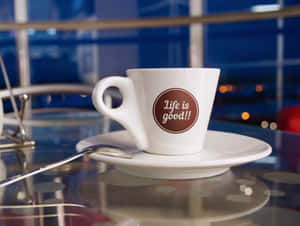 夜間玻璃桌上的白色咖啡杯，寫有「Life is good!!」。 — 咖啡 壁紙