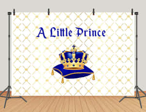 一個皇家藍色皇冠放在軟墊上，帶有「A Little Prince」文字，背景為金色菱格紋。 — 王子 壁紙