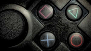 磨損的黑色遊戲控制器，帶有發光的彩色按鈕 — PlayStation GIF 壁紙