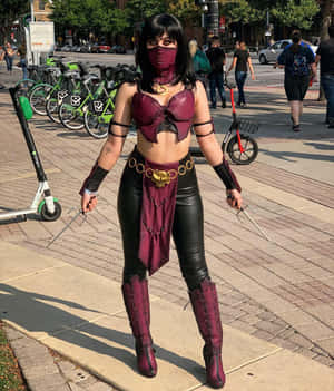 穿著紫色和黑色cosplay的人在人行道上手持劍 — Pixel Fold 壁紙