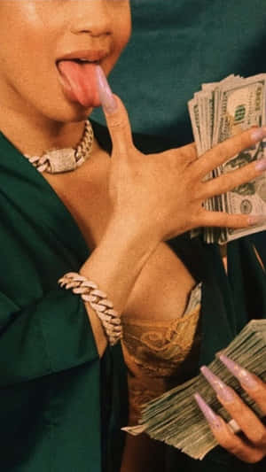 穿著綠色長袍的人伸出舌頭拿著現金，戴著金色珠寶。 — 美學 壁紙