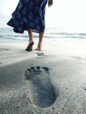 海灘濕沙上一個女人的赤腳腳印，伴隨著海浪。 — 海灘 壁紙