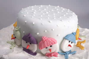 白色蛋糕裝飾著戴帽子和圍巾的彩色翻糖雪人。 — 甜品 壁紙