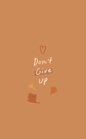 勵志文字 'Don't Give Up'，帶有心形和秋葉，置於溫暖的背景上。 — Nubia Flip2 壁紙