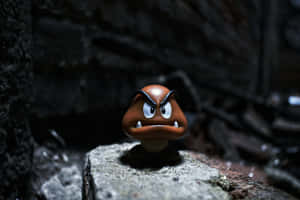 憤怒嘅Goomba玩具公仔喺黑暗環境中嘅石頭上 — Surface Pro 壁紙
