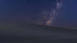 銀河系在繁星點點的夜空下在黑暗的山丘上發光 — 月色夜空 壁紙