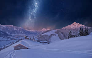 被雪覆蓋的山村，在星空下可見銀河。 — 冬天桌面 壁紙