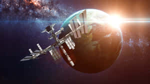 太空站繞地球運行，日出時背景是繁星點點的星系。 — 日出 壁紙