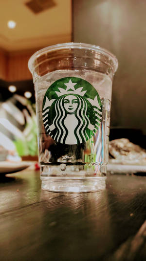 咖啡店木枱上嘅Starbucks水杯。 — 星巴克 壁紙