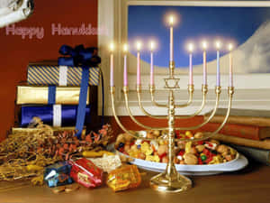 金色的燭台（Menorah）上點燃著蠟燭，周圍環繞著光明節禮物和甜點。 — 慶祝 壁紙