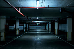 空的地下停車場，有螢光燈和混凝土柱。 — 最黑暗地牢 壁紙