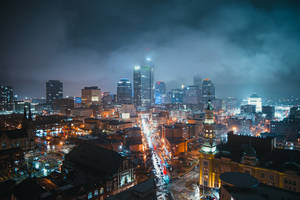 陰雲天空下，夜晚城市有閃爍建築物和濕漉漉的街道 — 唯美雲朵動態 壁紙