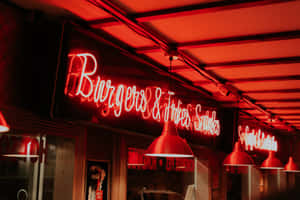 Burgers & Fries 的紅色霓虹招牌在夜晚照亮餐館，配有吊燈。 — 昏暗 壁紙