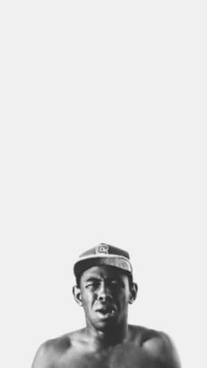 一個赤裸上身的男人戴著帽子，在攝影棚內表情嚴肅。 — Tyler the creator GIF 壁紙