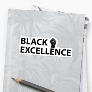 黑色拳頭貼紙，文字 Black Excellence，灰色筆記本和鉛筆。
