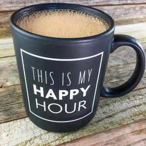 黑色馬克杯上印有白色文字 'This is my happy hour' 在木質表面上。 — 咖啡 壁紙
