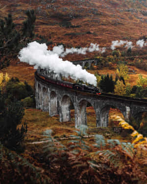 蒸汽火車在秋山中穿越石橋 — 霍格華茲 GIF 壁紙