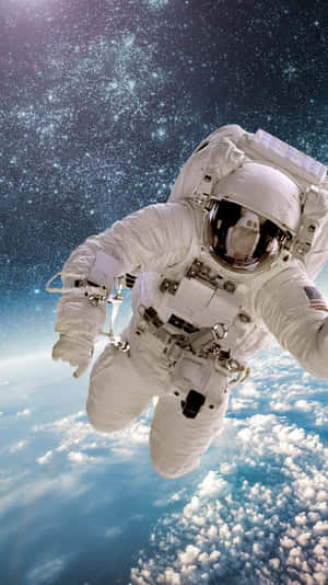 身穿白色太空衣的太空人漂浮在地球的雲層和星星之上。 — 太空人 壁紙