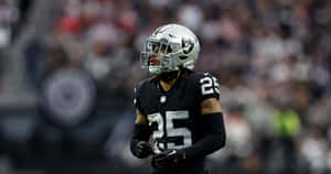 NFL美式足球員在比賽中身穿黑色和銀色球衣，背號25，站在球場上。 — 掠奪者 壁紙