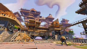 一名戴著黃色頭盔的Fortnite玩家站在一座大型木質和金屬結構前。 — 要塞英雄 大逃殺 壁紙