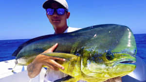 漁夫在公海的船上捧著一條巨大的鬼頭刀魚。 — 錦鯉 壁紙