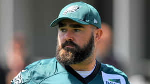 留鬍子的足球員穿著Eagles裝備望向一旁。 — 費城老鷹 壁紙