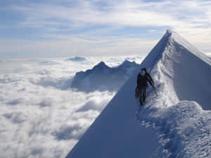 雲海上積雪山脊的登山者