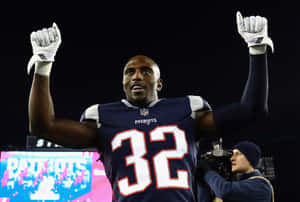32號美式足球員在夜晚高舉雙拳慶祝勝利。 — NFL 美式足球 GIF 壁紙