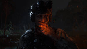 一名血跡斑斑的士兵在夜間叢林中，在頭盔燈下抽煙。 — 1920x1080 壁紙