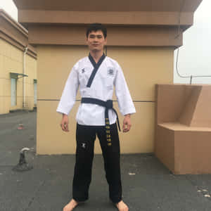 身穿跆拳道服的年輕男子赤腳站在屋頂上 — iPad Pro 13 壁紙