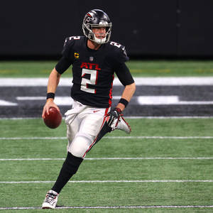美式足球四分衛在球場燈光下帶球奔跑 — NFL 美式足球 GIF 壁紙