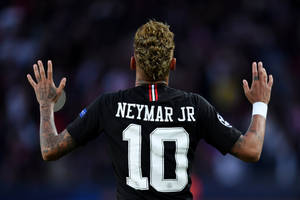 身穿黑色10號球衣的足球員尼馬（Neymar Jr）向觀眾高舉雙手。 — 足球 壁紙
