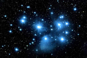 深空中一團密集的明亮藍色恆星，帶有淡淡的星雲雲氣。 — 星星 壁紙